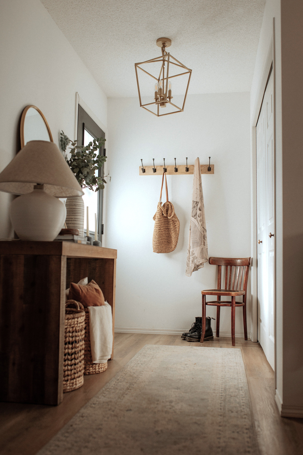 a welcoming entryway with white walls and wooden flooring designed by interior decorator near me in Edmonton Alberta