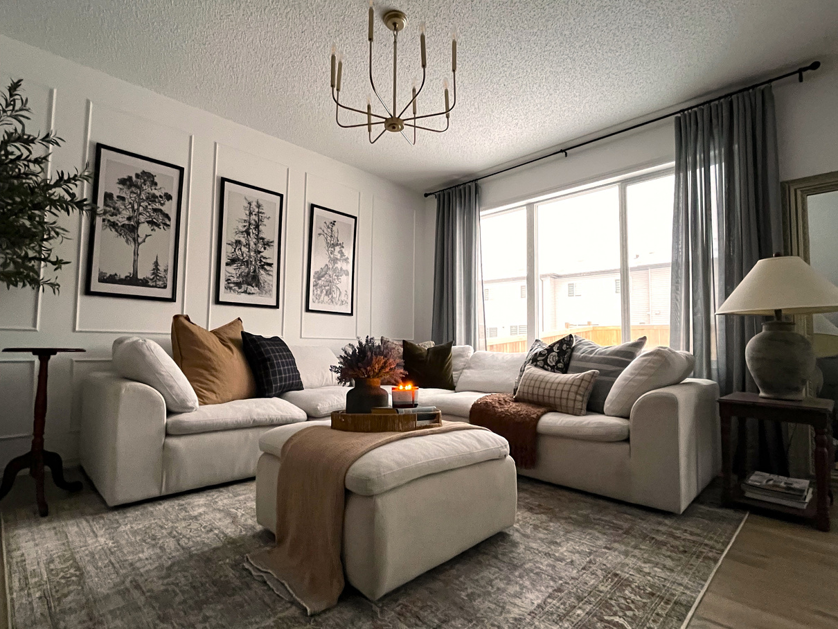 a cozy living room with white couch and a chandelier designed by interior designer in Edmonton Alberta