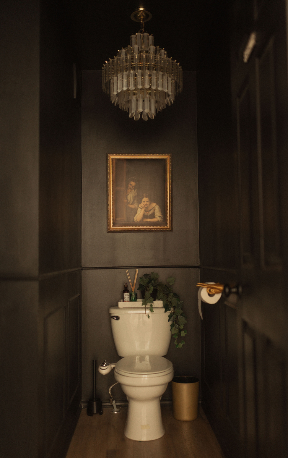 a dark classy moody glam black bathroom with black walls and a chandelier small bathroom 