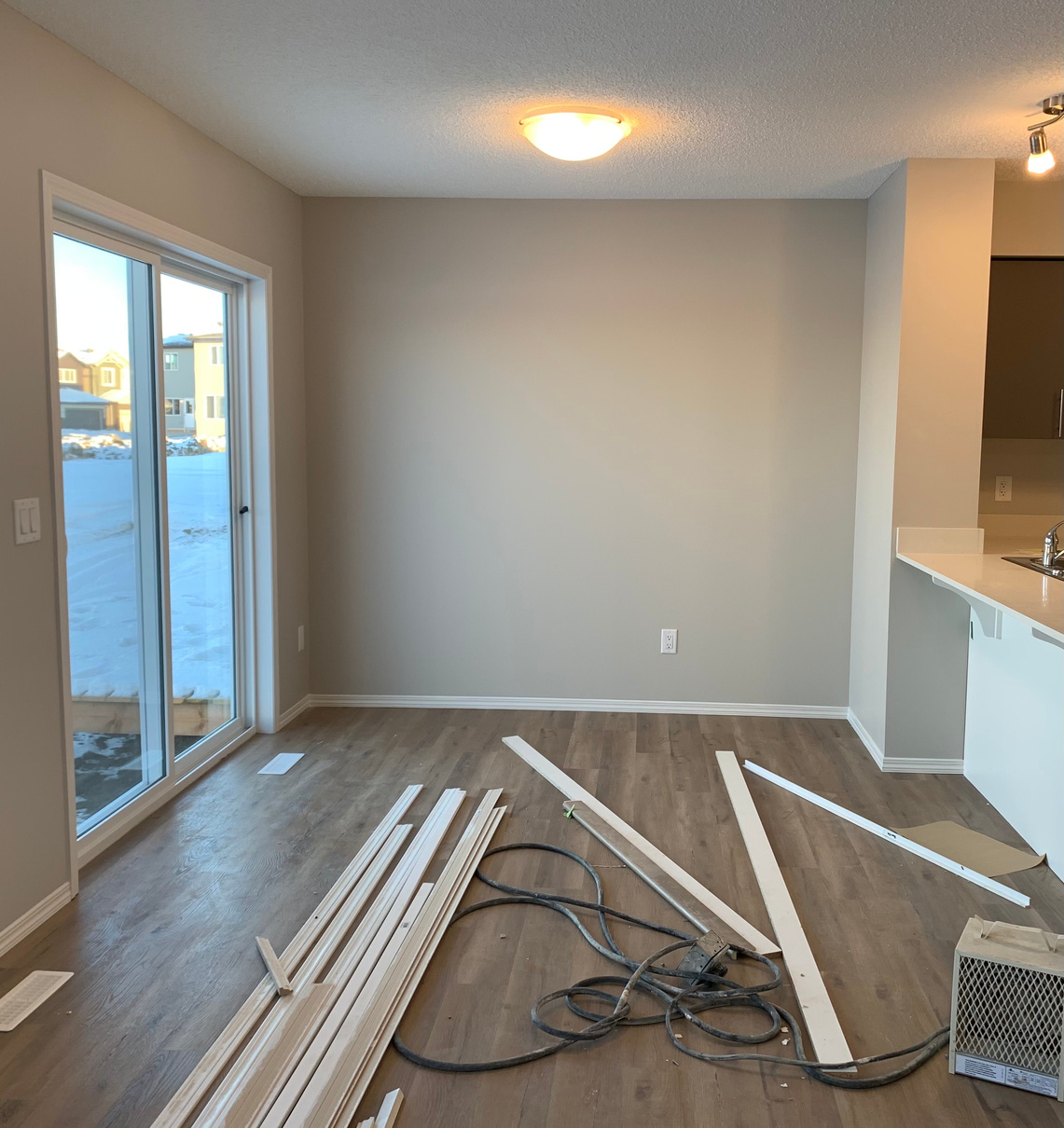 an empty room with wood flooring and white walls by Sterling Home in Edmonton Alberta